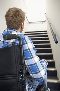 Man in wheelchair at foot of stairs