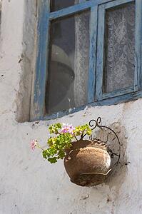 A Flower Pot Mounted On An Exterior Wall Below A Window; Barrio De San Blas; Cusco Peru