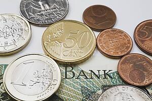 American And Euro Coins On Top Of A Foreign Currency Bank Note