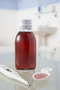 Thermometer and medicine on bathroom shelf