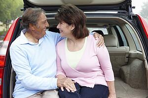 Senior Hispanic couple outdoors with car