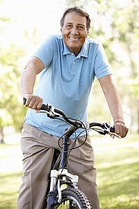 Senior Hispanic man riding bike