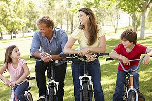 Family riding bikes in park