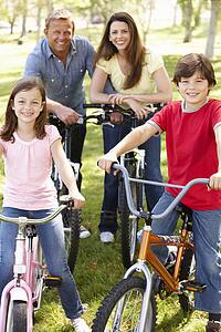Family riding bikes in park