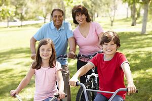 Hispanic family riding bikes in park
