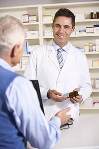 American pharmacist with senior man in pharmacy