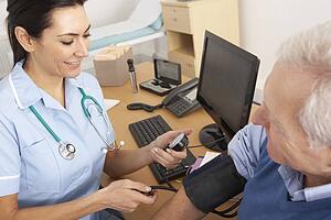 British nurse taking senior man's blood pressure