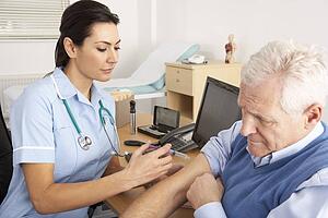 British nurse giving injection to senior man