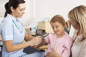 British nurse giving injection to young child