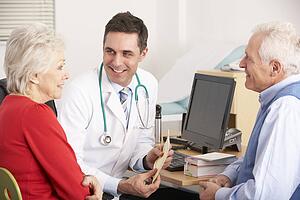 American doctor talking to senior couple in surgery