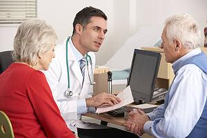 American doctor talking to senior couple in surgery