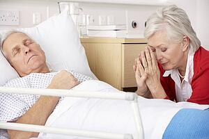 Senior woman with seriously ill husband in hospital