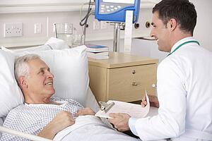 Doctor with senior male patient on USA Hospital ward