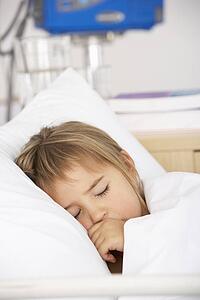 Young girl asleep in Accident and Emergency bed