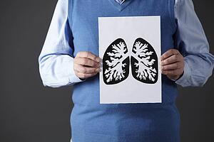 Senior man holding ink drawing of lungs