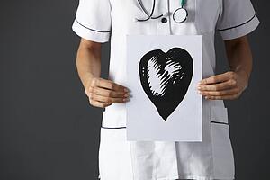 American nurse holding ink drawing of heart