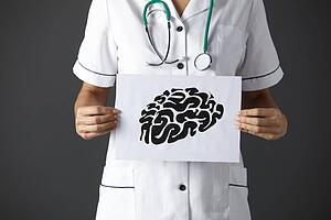 American nurse holding ink drawing of brain