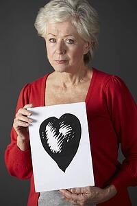 Senior woman holding ink drawing of heart
