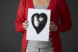 Senior woman holding ink drawing of heart