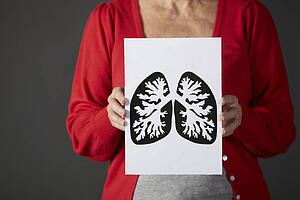 Senior woman holding ink drawing of lungs