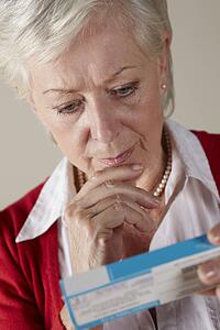 Senior woman looking at prescription drug pack