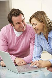 Mature couple using laptop in domestic kitchen