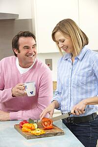 Mature couple preparing meal in domestic kitchen