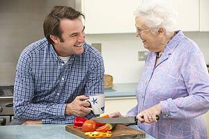 Mother and adult son preparing meal together