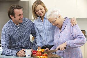 Senior woman and family preparing meal together