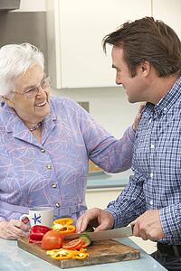 Mother and adult son preparing meal together