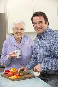 Mother and adult son preparing meal together