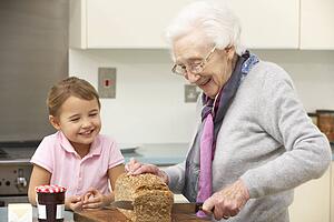 Grandmother and granddaughter preparing food in kitchen