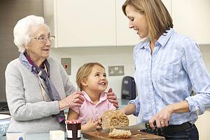 Multi-generation family preparing food in kitchen