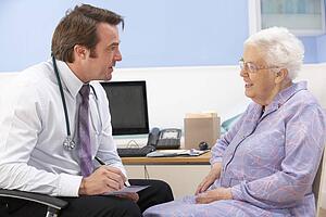 UK GP talking to senior woman patient