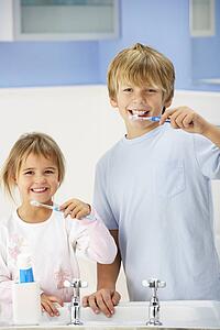 Boy and girl cleaning teeth in bathroom