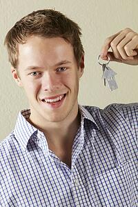 Studio Shot Of Young Man Holding Keys To First Home