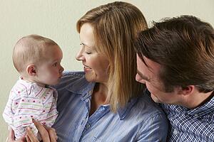Studio Shot Of Happy Family With Baby