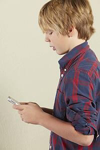 Studio Shot Of Young Boy Holding Tablet Computer