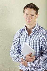 Studio Shot Of Young Man Holding Tablet Computer