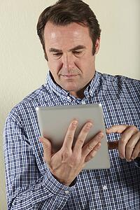 Studio Shot Of Middle Aged Man Using Tablet Computer