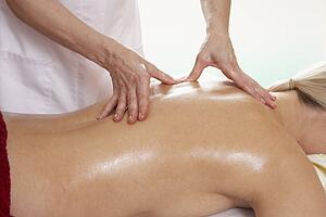 Woman with tattoo having back massage