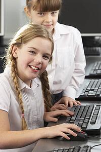 Girls using computers in school class