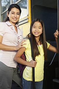 Teacher seeing pupil onto school bus