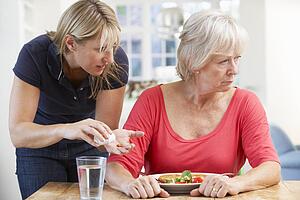 Older woman refusing medication at home