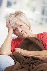 Sick, unhappy older woman at home