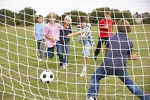 Boys playing soccer in park