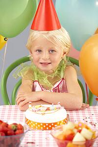 Young girl with birthday cake at party
