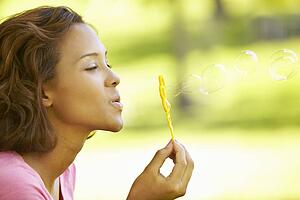 Young woman blowing bubbles