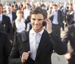 Male commuter in crowd using phone