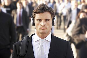 Male commuter in crowd wearing headphones